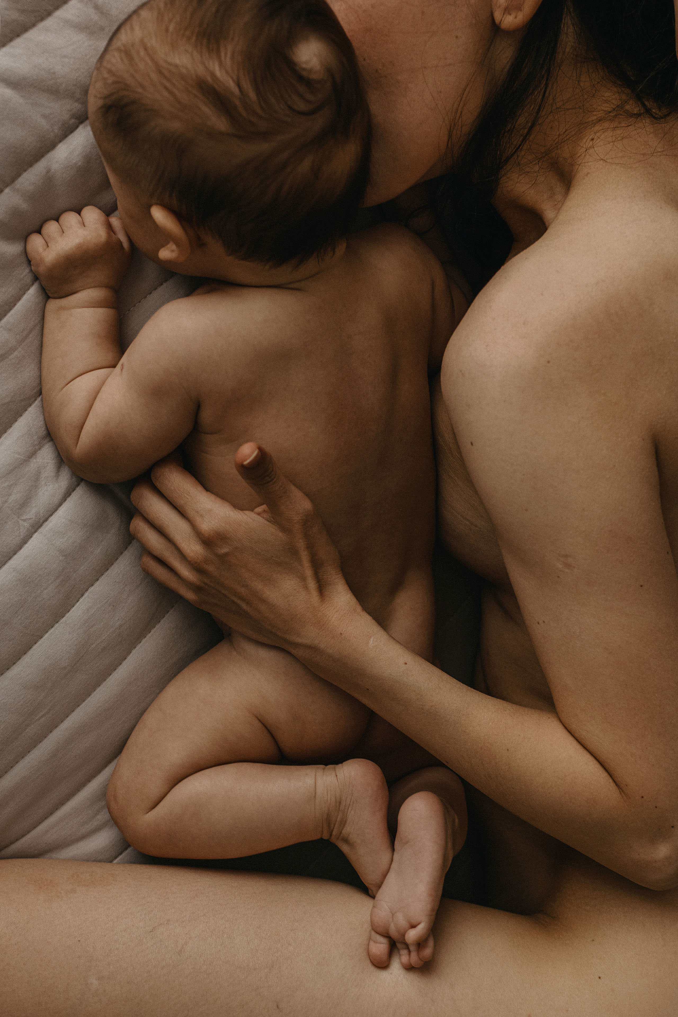 A mother holding her baby close to her chest.